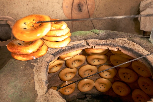 Making Uzbek cakes in a large clay tandoor