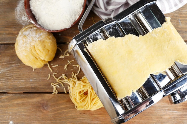 Making vermicelli with pasta machine on wooden background