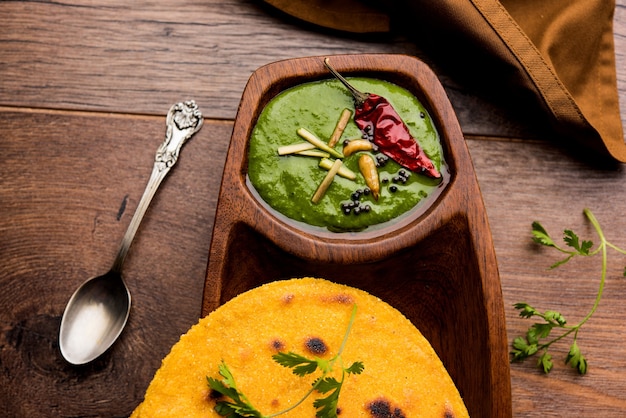 Makki di roti met sarson ka saag, populair punjabi hoofdgerecht recept in de winter gemaakt met maïsbrood mosterdblaadjes curry. geserveerd op humeurige achtergrond. selectieve focus