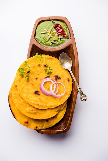 Foto makki di roti con sarson ka saag, popolare ricetta del piatto principale punjabi in inverno a base di pane di mais, senape e foglie di curry. servito su sfondo lunatico. messa a fuoco selettiva