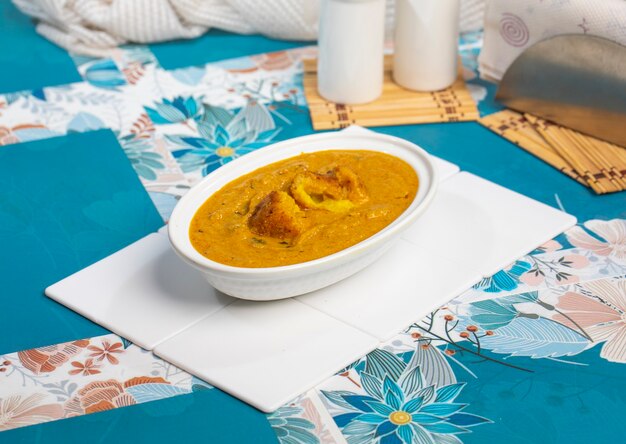 Malai kofta curry on bowl at white background. malai kofta is famous indian cuisine dish with potato, paneer and cheese deep fried balls in onion tomato gravy with spicy indian's spices