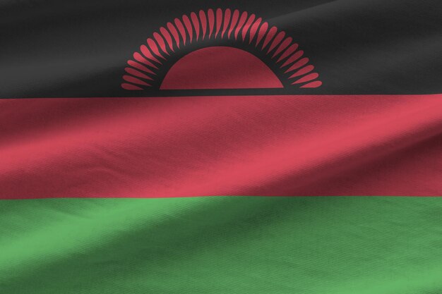 Флаг Малави с большими складками, развевающимися крупным планом под студийным светом в помещении Официальные символы и цвета на баннере