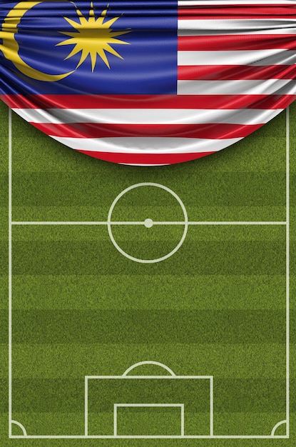 サッカーのサッカー場の3Dレンダリングに掛けられたマレーシアの国旗