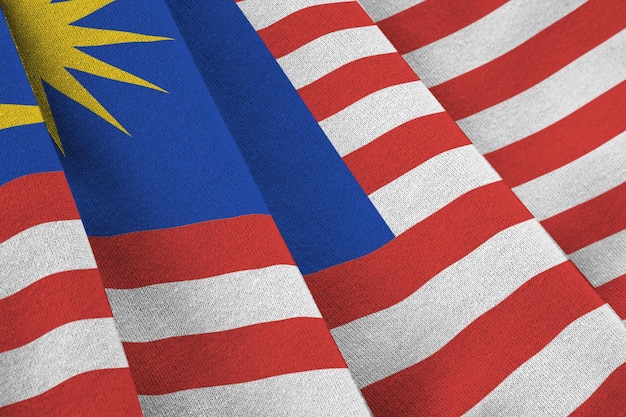 Malaysia flag with big folds waving close up under the studio light indoors the official symbols and