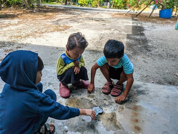 Malaysia Perak 26 September 2021 Three boys are seen having fun playing with soap bubbles in their backyard