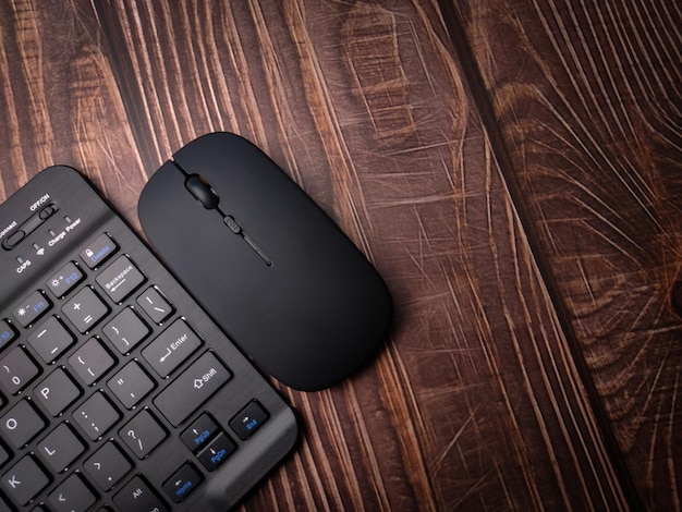 Malaysia30 april 2022 black bluetooth wireless keyboard and\
wireless mouse on a wooden background