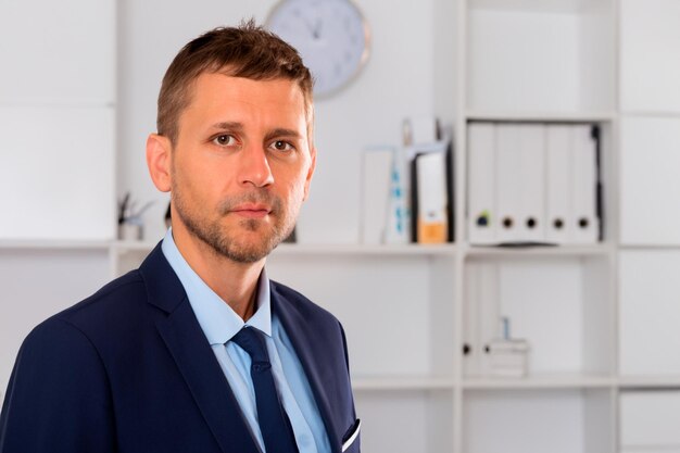 Male accountant in blue shirt suit and navy tie in office