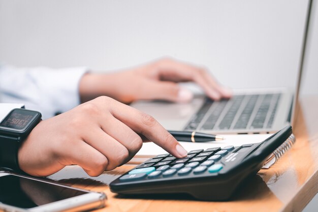 Male accountant making calculations,reviewing data in financial charts and graphs  at work place. Business financial  concept.