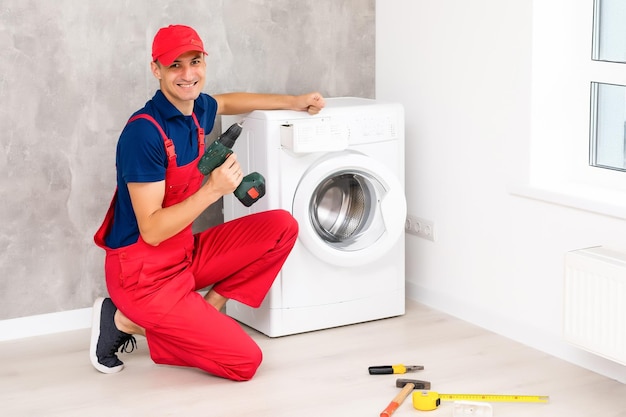 male adult repairman with tool and clipboard checking washing machine in bathroom