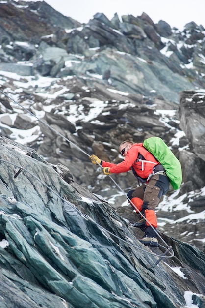 Male alpinist climbing rocky mountain