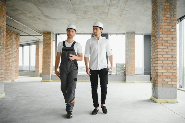 Male Architect Giving Instructions To His Foreman At Construction Site