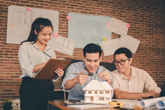 Male architect hands measuring and making model house with them
team on the desk at sunset. engineer, engineering, architecture,
design, planning, occupation concept.