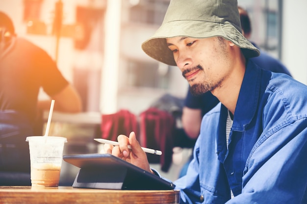 Male Architect With Digital Tablet Studying Plans In Office