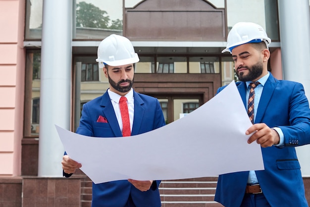 male architects holding a blueprint