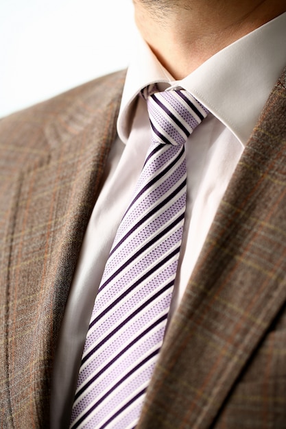 Male arm in brown suit set tie closeup