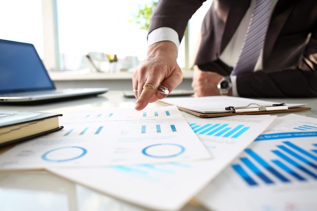 Male arm point finger at important paper on table