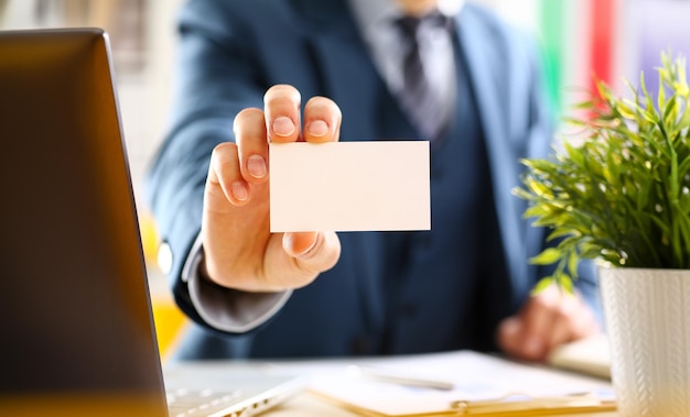 Male arm in suit give blank calling card to visitor closeup White collar colleagues company name exchange job interview sale clerk id executive or ceo finance support formal identity concept