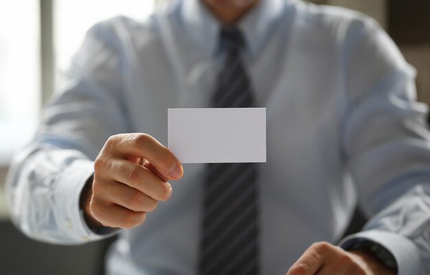 Male arm in suit give blank calling card to visitor