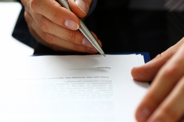 Male arm in suit and tie fill form clipped to pad