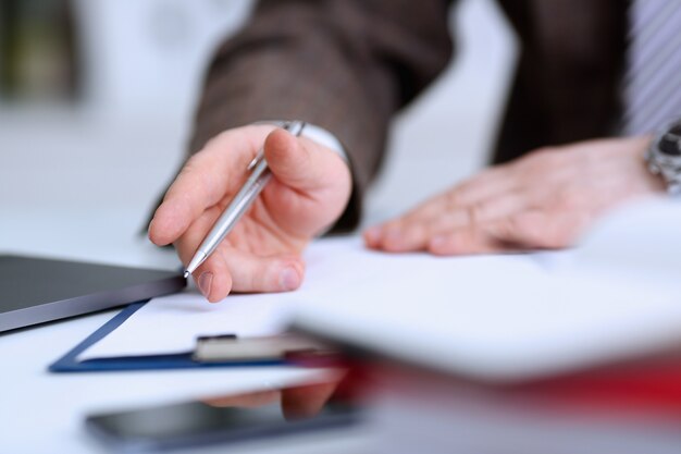 Male arm in suit and tie hold silver pen