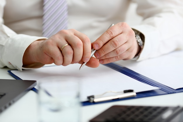 Male arm in suit and tie hold silver pen