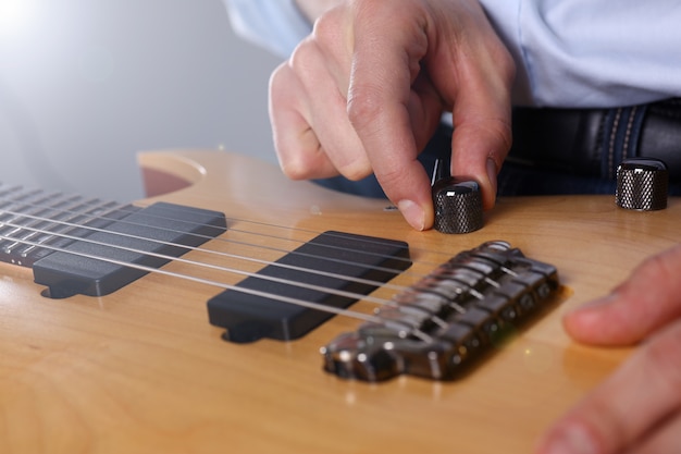 Male arms playing classic shape electric guitar