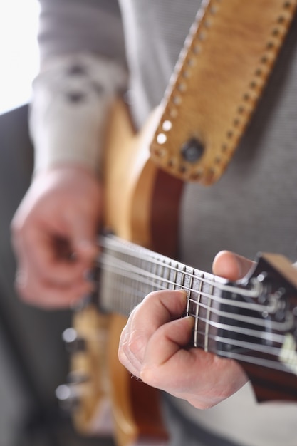 Male arms playing classic shape electric guitar