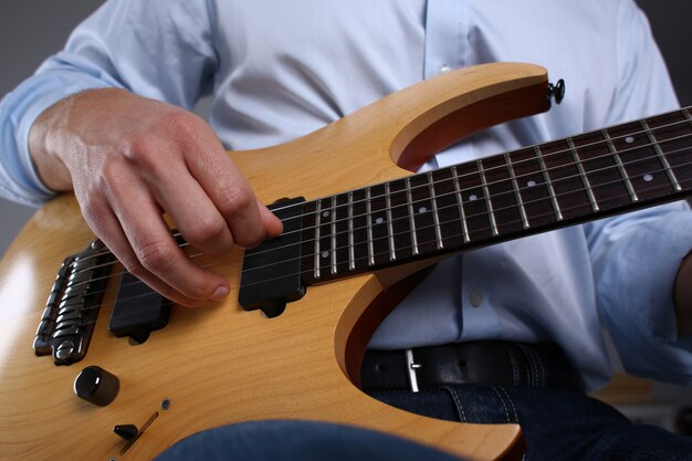 Male arms playing classic shape electric guitar