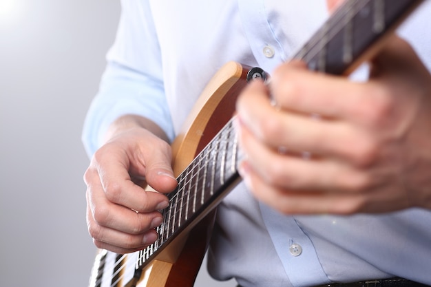 Male arms playing classic shape electric guitar