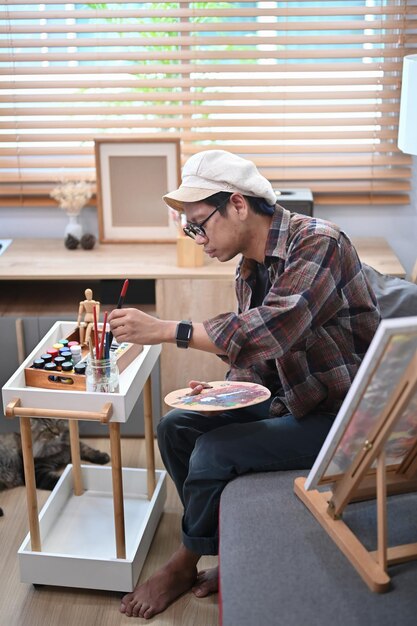 Male artist painting with watercolor at art studio