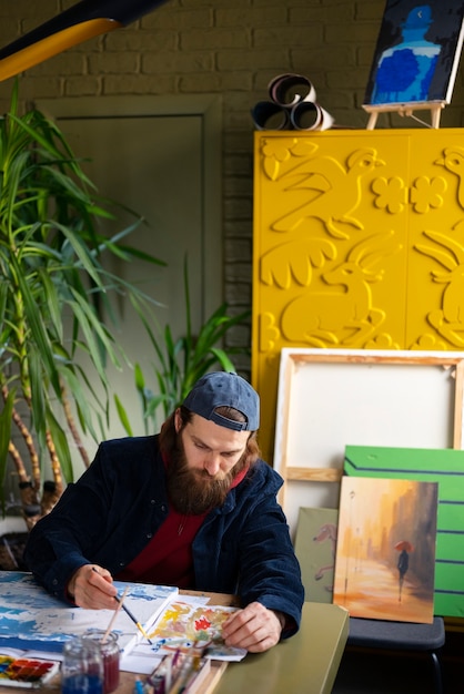 Male artist painting with watercolor in the studio