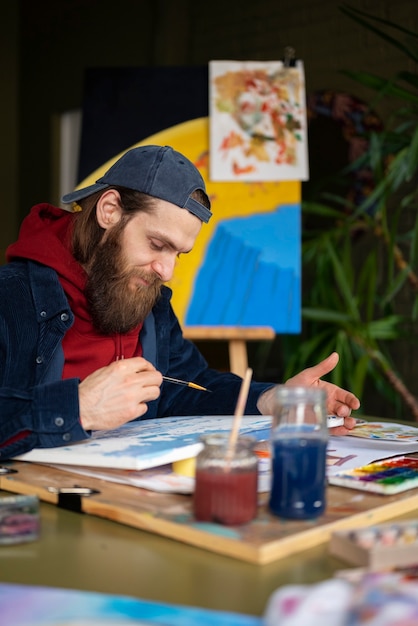 male artist painting with watercolor in the studio