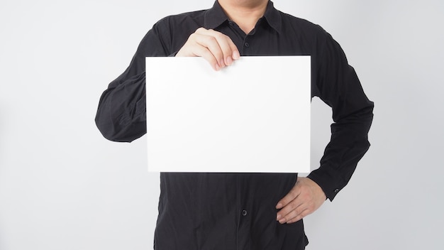 Мужской азиатский держать чистый лист бумаги и носить черную рубашку на белом фоне.