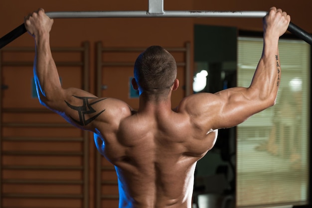 Male Athlete Doing Pull Ups  ChinUps In The Gym