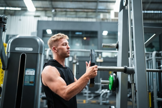 Male athlete exercising in the gym lifting weights pulling joints