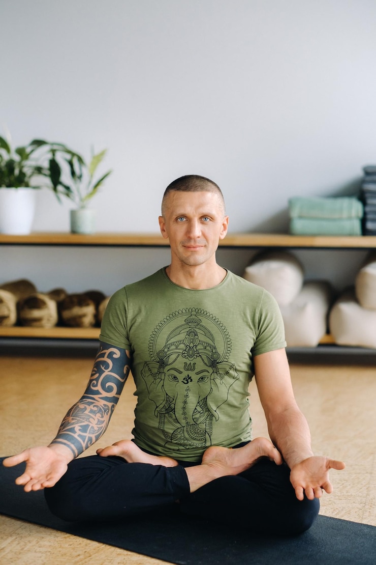 Photo a male athlete in a green tshirt sits in the gym before a yoga workout