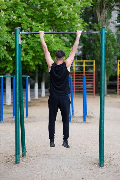 A male athlete is engaged in a horizontal bar on a sports ground