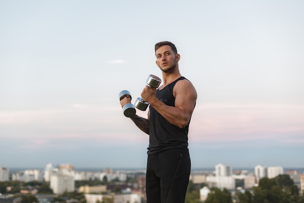 Male athlete muscular body doing exercises on street