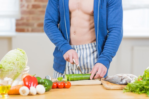 Atleta maschio che prepara cibo sano a casa in cucina