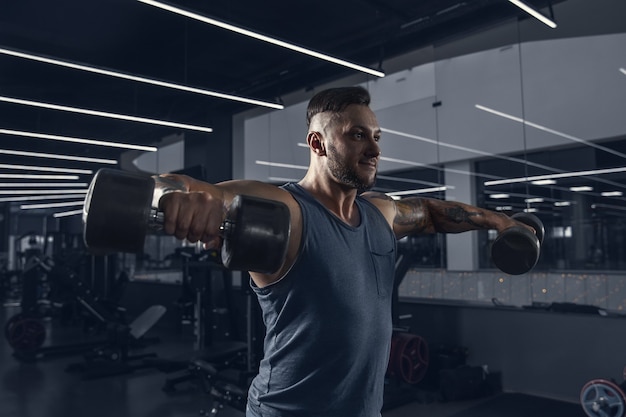 The male athlete training hard in the gym