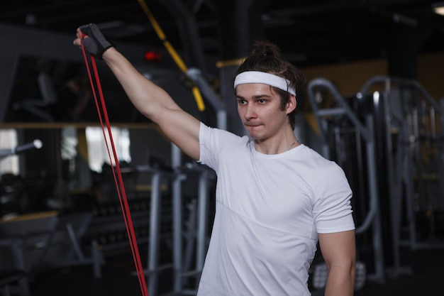 Male athlete training with resistance band at gym