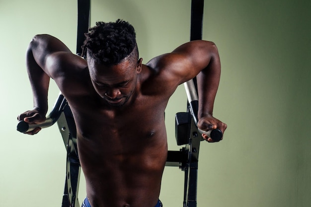 Male athletewith dreadlocks working out in the gym