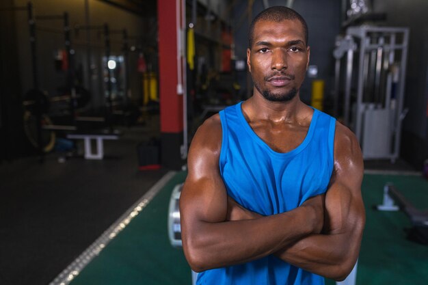 Male athletic standing with arms crossed in fitness center