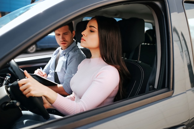 Male auto instructor takes exam with young woman