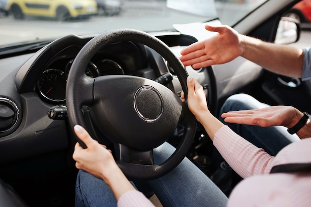 Male auto instructor takes exam with young woman