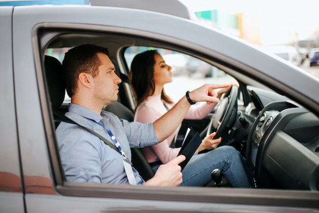 Male auto instructor takes exam with young woman