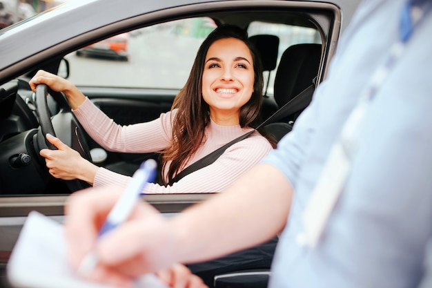 Male auto instructor takes exam with young woman