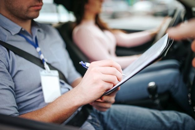 Male auto instructor takes exam in young woman