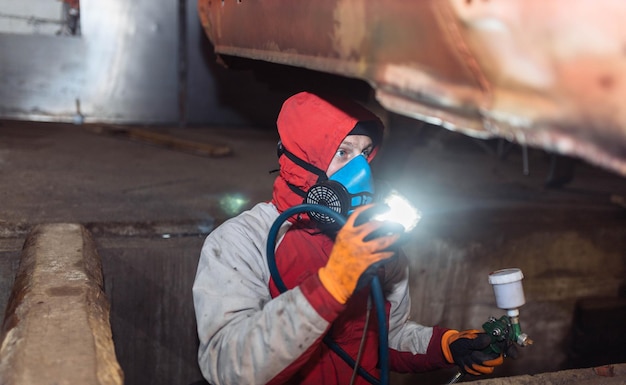 male auto mechanic examines the bottom of the car diagnostics