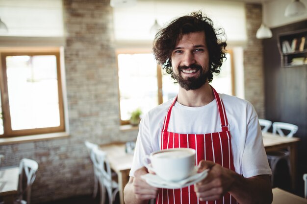 一杯のコーヒーを保持している男性のパン屋